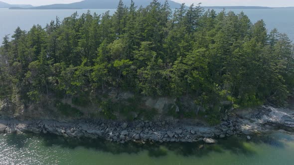 Aerial with boom up over beautiful tiny island in Puget Sound in an inlet of the Salish Sea in Belli