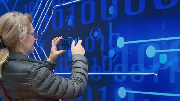 A Woman Photographs on Her Smartphone a Special Message in the Form of a Binary Code on a Blue