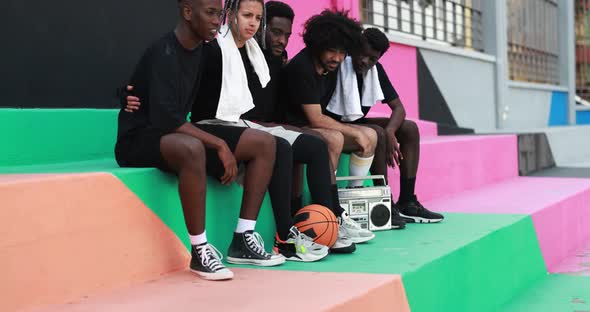 Young multiracial people listening music from vintage boombox stereo in the city