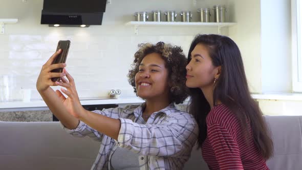 Asian and African American Black Woman Taking Selfie Using Smartphone