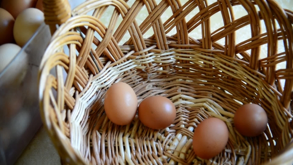 Woman Adds Eggs In Wicker Basket