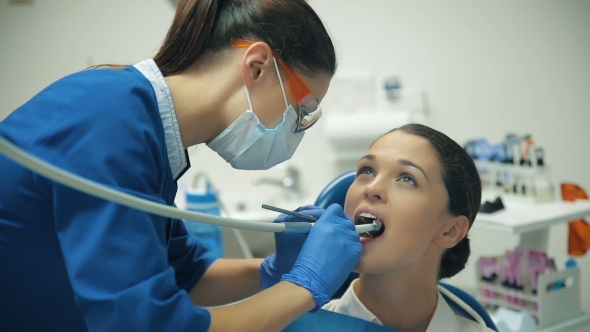 Woman Treats Teeth At The Dentist
