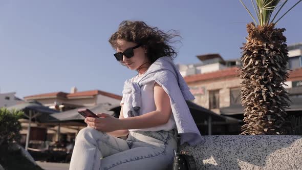 Cheerful woman wearing casual clothes browsing the internet or chatting in social networks