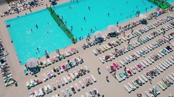 Aerial: Flying Over the Beach, Lot of People Are Sunbathing, Swimming in the Pool