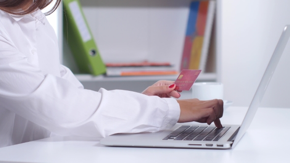 Girl Doing Online Shopping In Office In Front Of Laptop. 