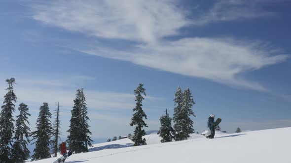 Snowboarders with Snowboard Climbing in Snowy Mountain with Amazing Sea