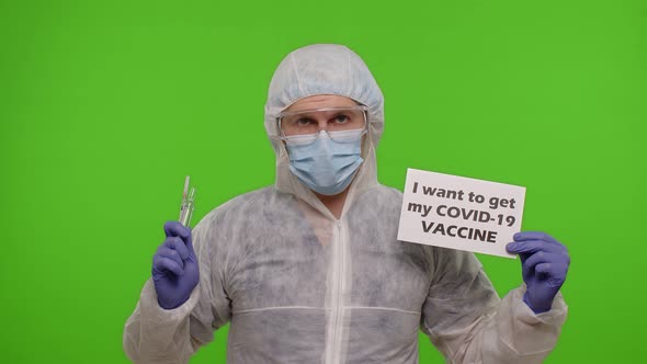 Doctor in Suit with Syringe Ampoule and Text Slogan on Paper  I Wand To Get My Covid19 Vaccine