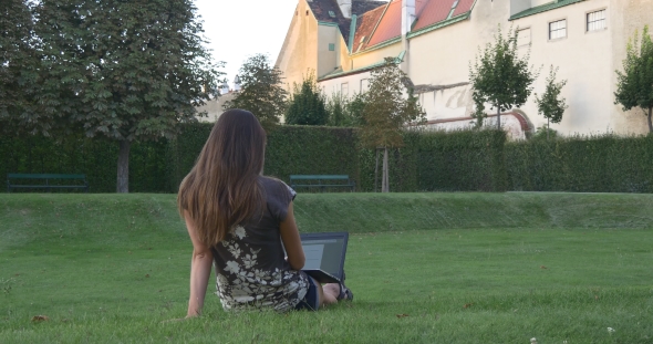 Woman With Laptop In The City Garden