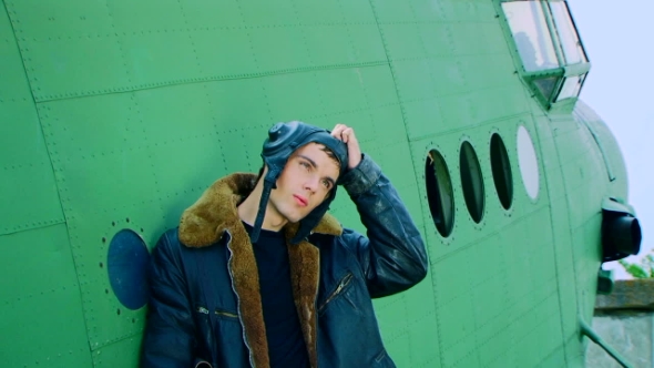 Man Standing Near to the Plane and Taking off a Flight Helmet