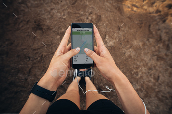 e. POV shot of woman runner using a fitness app on her cellphone.
