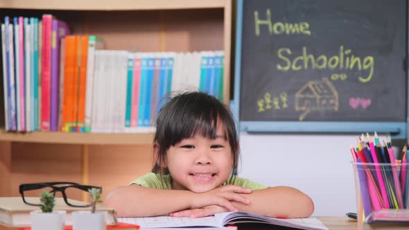 Asian female students studying at home during quarantine. New Normal. Home schooling.