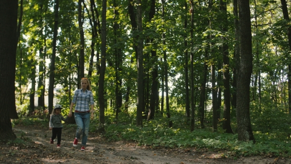 Mother And Baby Walk On Country Rural Road In Pine Forest