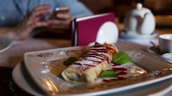 Strawberry Pancake On The Plate And Man With Phone On Background