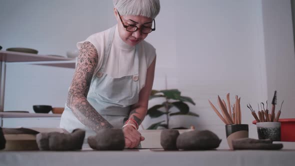 Asian elderly woman enjoying pottery work at home.