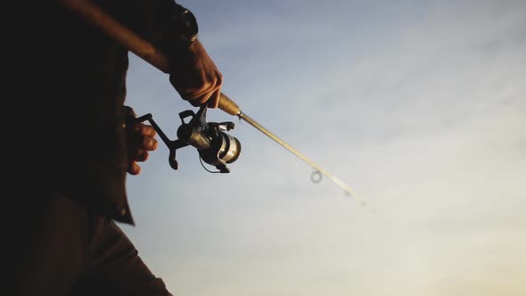 Silhouette Of A Fisherman Casting A Fishing