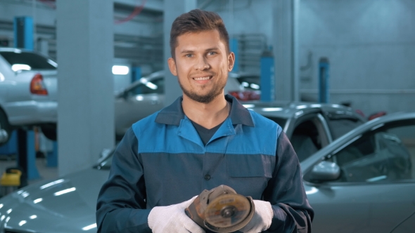 Portrait of Professional Smiling Car Mechanic Working in Modern Auto Repair Service