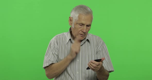 Senior Man Works on a Smartphone. Handsome Old Man on Chroma Key Background