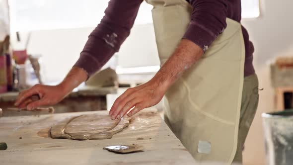 Male potter working on clay in pottery workshop