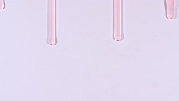 Pink Transparent Cosmetic Gel Fluid With Molecule Bubbles Flowing On The Plain White Surface