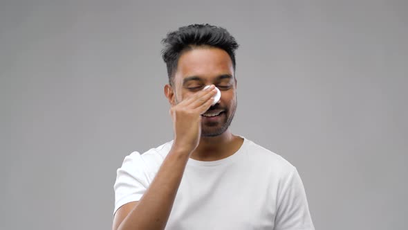 Smiling Indian Man Cleaning Face with Cotton Pad 9