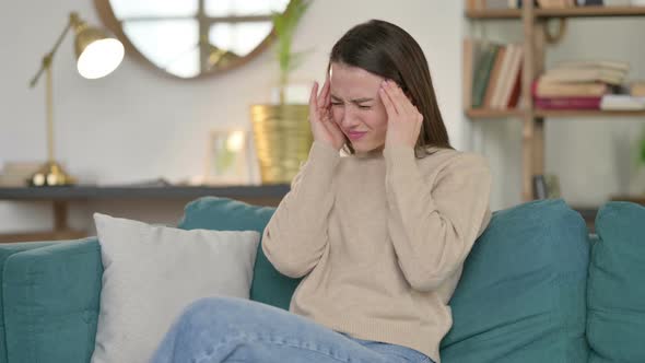 Stressed Young Woman with Headache on Sofa 