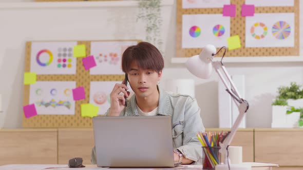 Working man typing on laptop while sitting at desk in modern living room