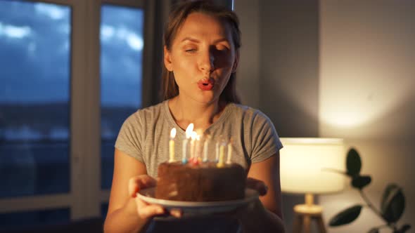 Happy Excited Woman Making Cherished Wish and Blowing Candles on Holiday Cake Celebrating Birthday