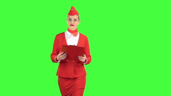 Woman Steps Along with a Red Folder in Her Hands. Green Screen