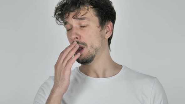 Tired Young Casual Man Yawning on White Background