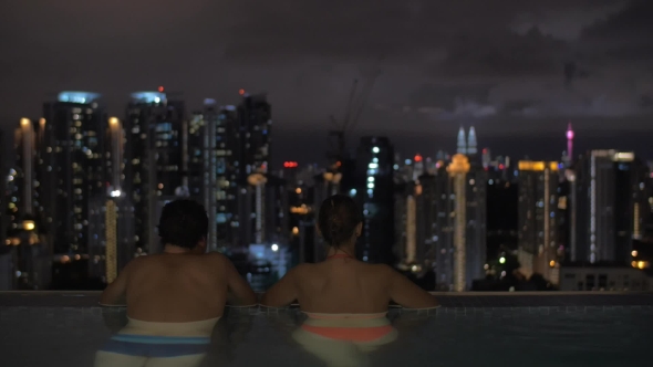 Couple Looking At Night Kuala Lumpur From Rooftop Pool, Malaysia