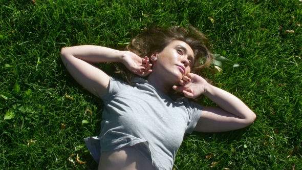 Young Girl Lying On The Grass And Dreaming