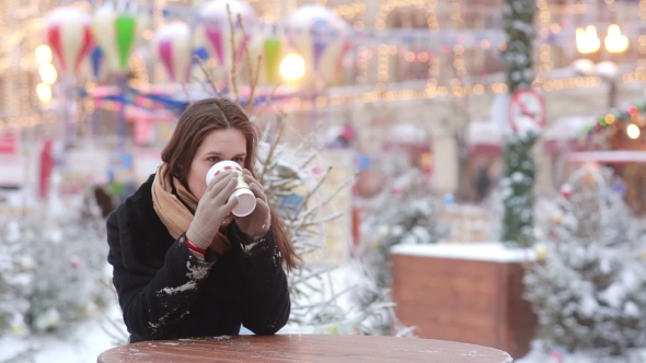 Beautiful Young Woman Drinking Hot Tea During Christmas Fair