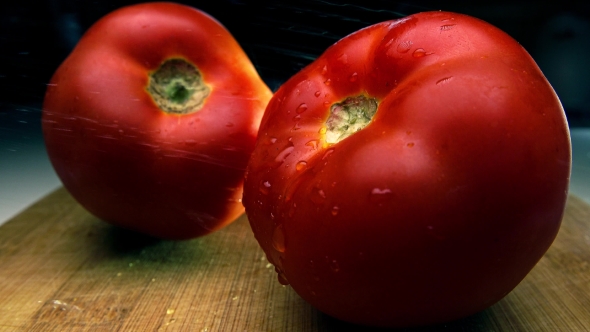 Ripe Whole Tomatoes On Wooden Cutting Board Being Sprayed With Water