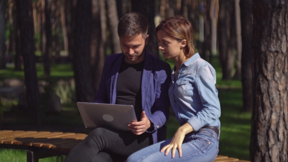 Businessman And Businesswoman Meet At The Open Air Discussing Project.