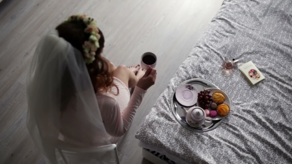 Bride Is Sitting On a Chair And Drinking Coffee.