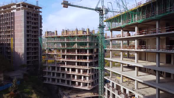 Workers and cranes on the building construction complex