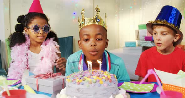 Boy blowing candles on cake during birthday 4k