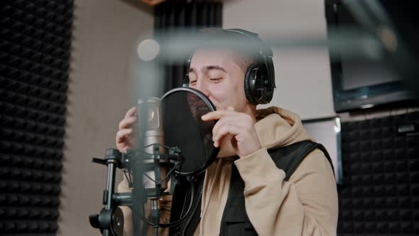 A Man Rapper Recording His Track in the Studio