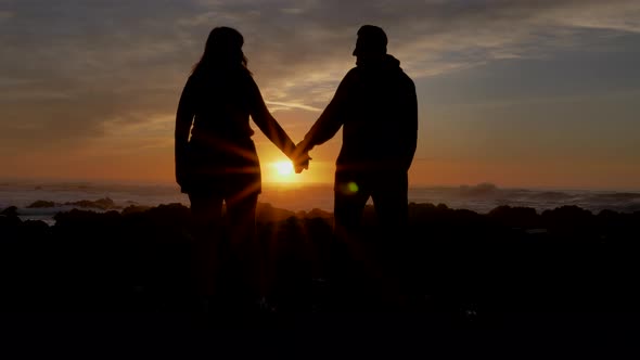 Slow Motion Couple Joining Hands Together with Sunlight in Background