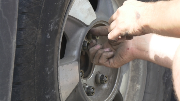 Man Replaces Tire On a Roadside