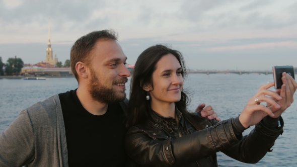 Beautiful Young Couple Taking Selfie On The Background Of River And The City. Peter And Paul