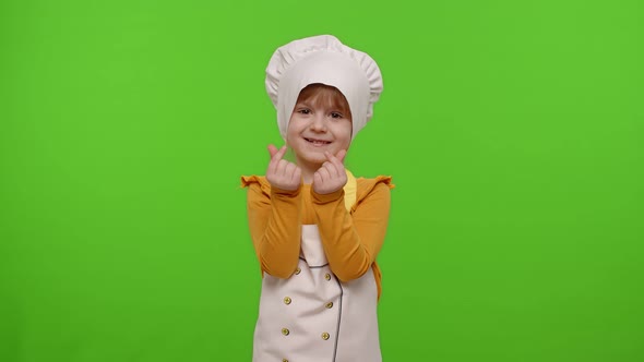 Child Girl Dressed in Apron and Hat Like Chef Cook Asking To Pay Her Money Concept of Cooking Store