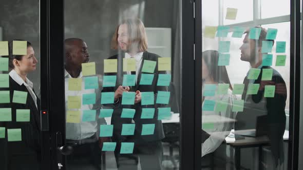 Business Meeting International Management Team at Work Team is Standing Next to a Glass Board with