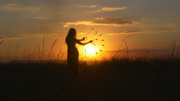 Woman Dancer Performs a Fire Show In Front Of The Sun