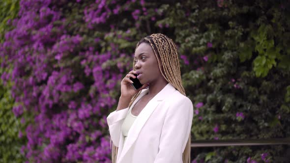 Business Woman Speaking Mobile Phone on the Go to Office Outdoors