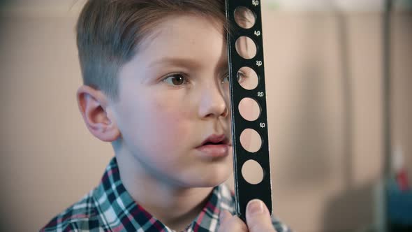 A Little Boy Having a Treatment in Eye Clinic - a Doctor Checking an Eye Visibility of a Little Boy