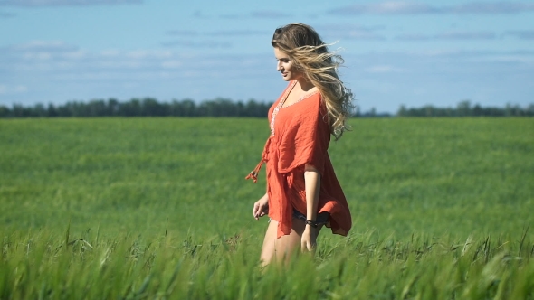 Beautiful Blonde Young Happy Woman In a Red Shirt Walking Slowly