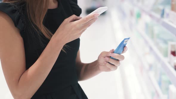 Close Up Side View of Young Woman Checks the Cosmetics with Smartphone