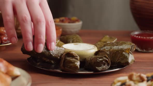 Eating Dolma Closeup Meat in Grapes Leaves with Sour Cream