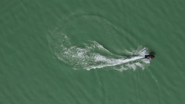 Rider on Sea Doo Jet Ski Speeding on Water Surface of Lake, Aerial Overhead